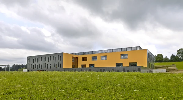 Un volume unitaire, ancré dans la pente, qui orchestre les flux, la lumière et les fonctions autour d’un espace central généreux.