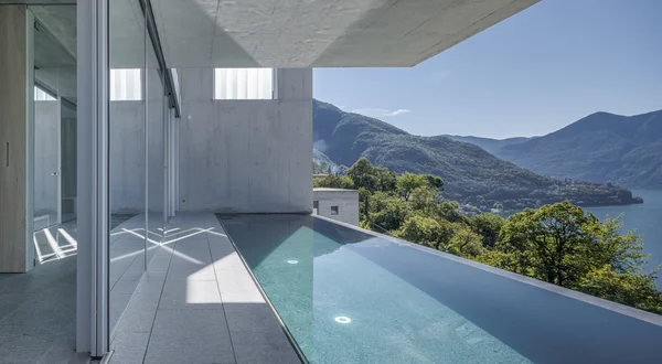Two architecturally designed holiday homes on a Ticino hillside feature lake views, terraces, and integrated pools.